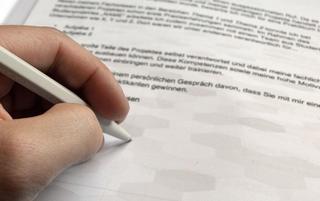 Person unterschreibt Bewerbungsbrief