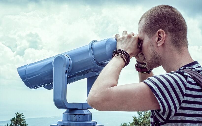 Mann schaut durch ein Fernglas