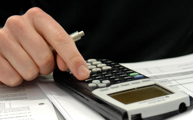 Eine Person bedient einen Taschenrechner