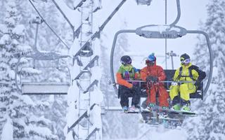 Skifahrende auf einem beschneiten Sessellift