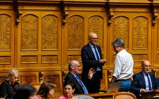Mitte-Nationalrat Nicolò Paganini (stehend, Mitte) mit Ratskolleginnen und -kollegen während der Herbstsession im Nationalratssaal.