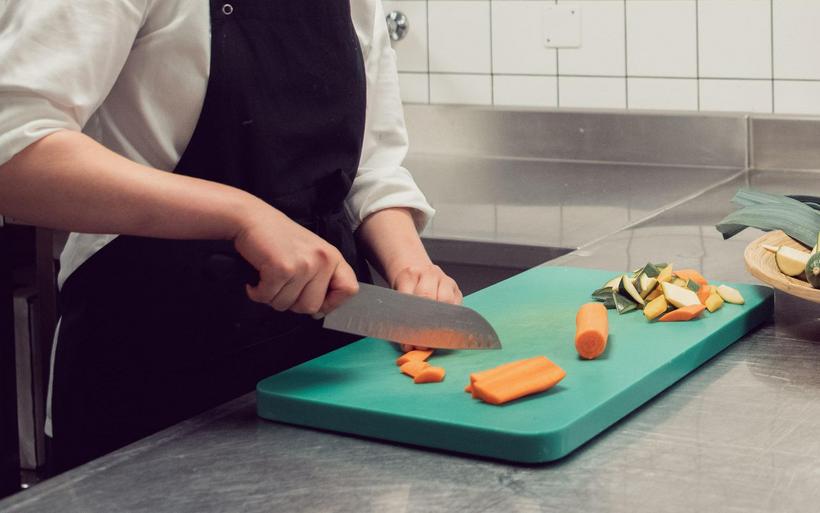 Professioneller Koch schneidet Gemüse