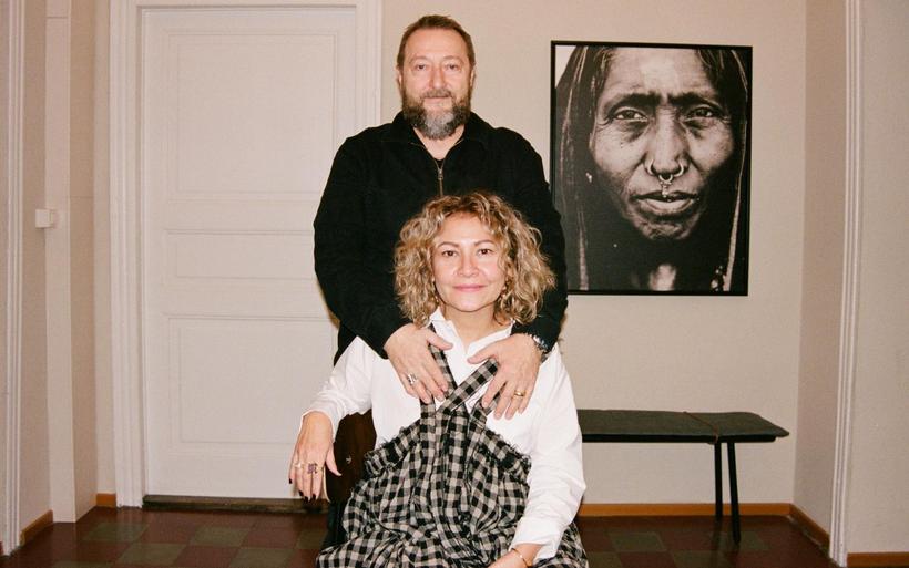 Eine Person sitzt, eine andere Person steht hinter ihr und legt die Hände auf die Schultern