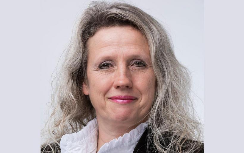 Portrait einer Frau mit langen grauen Haaren und heller Haut.